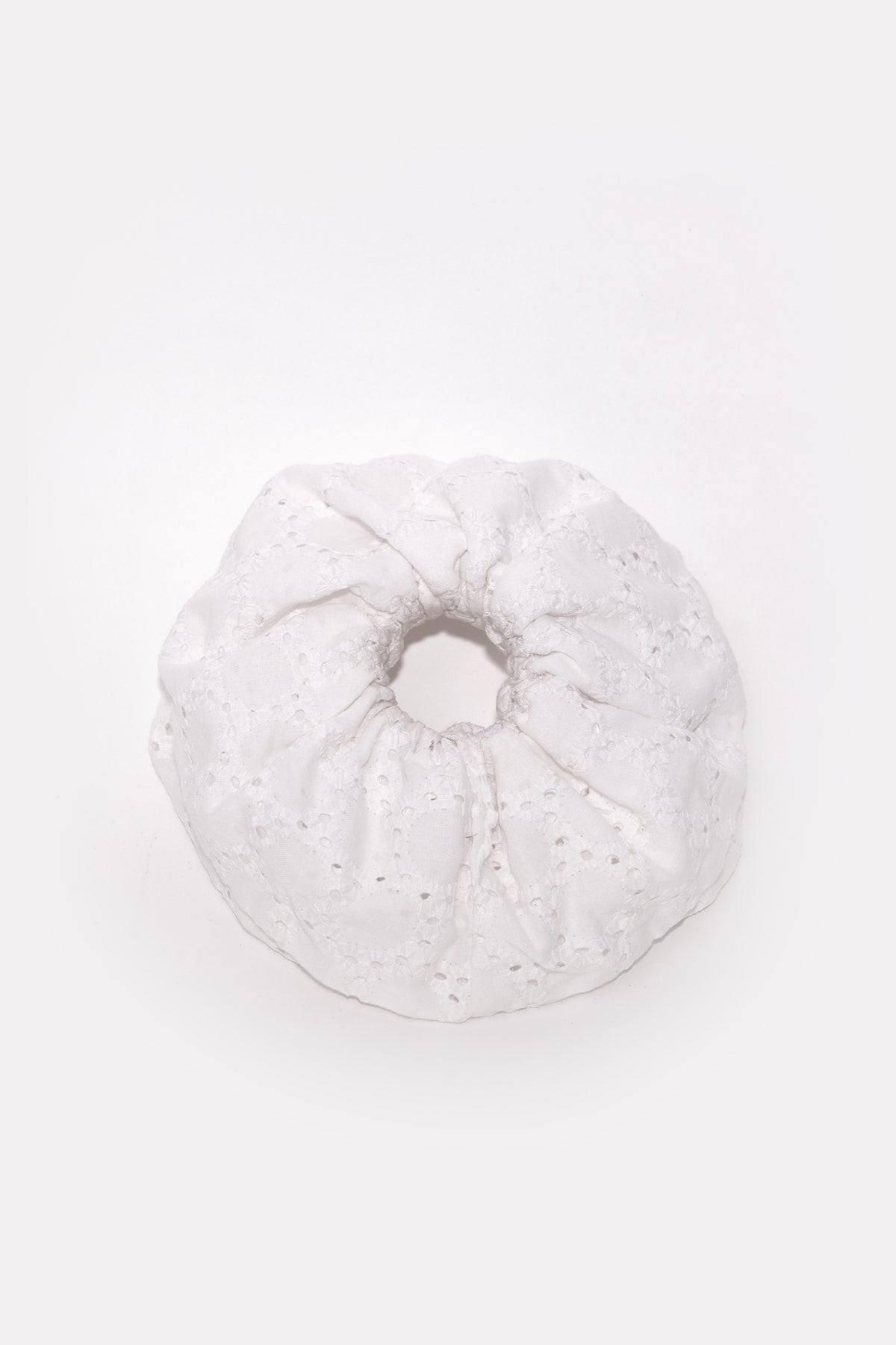 Cloudy laid flat from above: a full ring of white chikankari gathered around its elastic