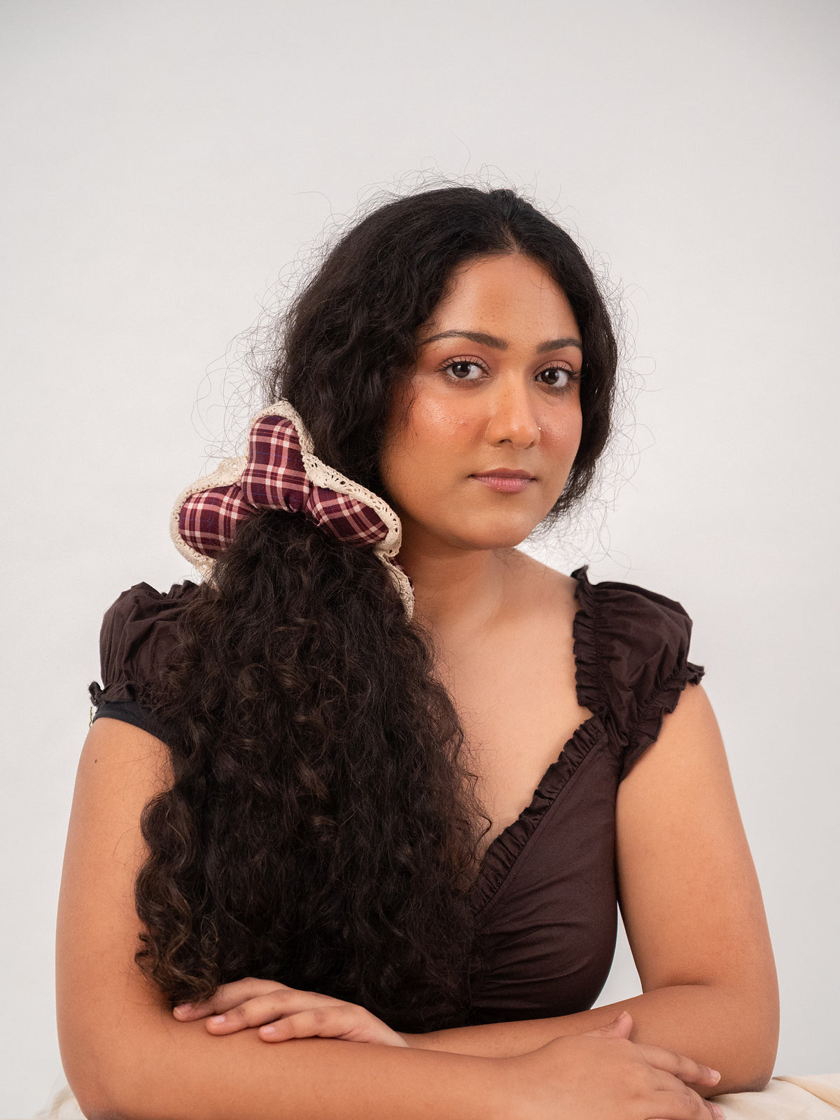 Facing the camera, the silk Wildpetal perched in long curly hair