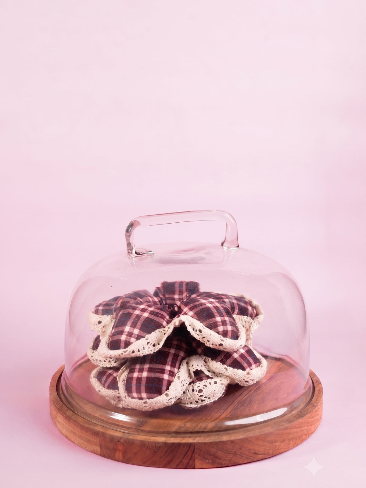 The silk Wildpetal resting under a glass cloche on a pink backdrop