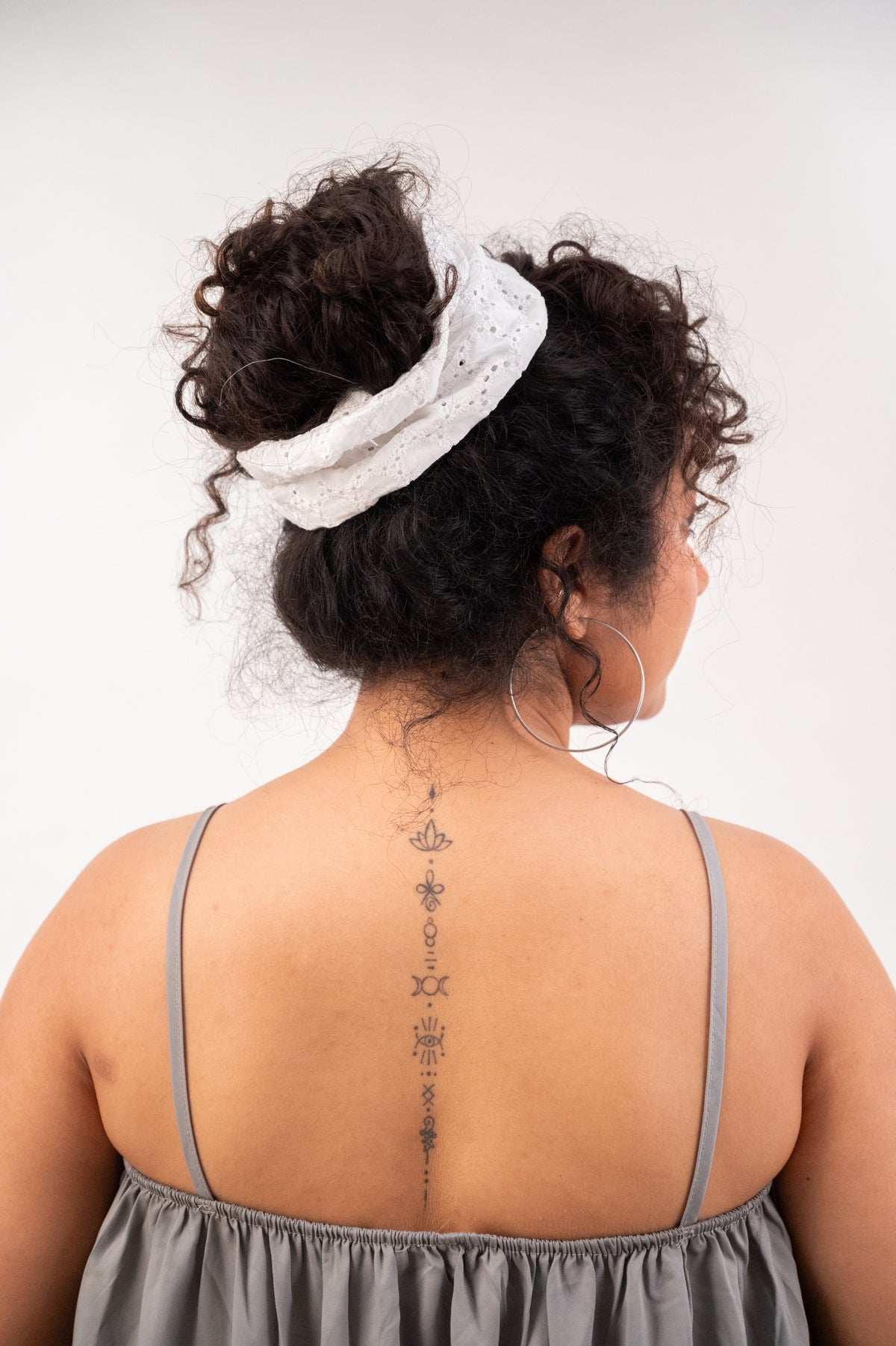 A curly high bun held by Cloudy, seen from behind