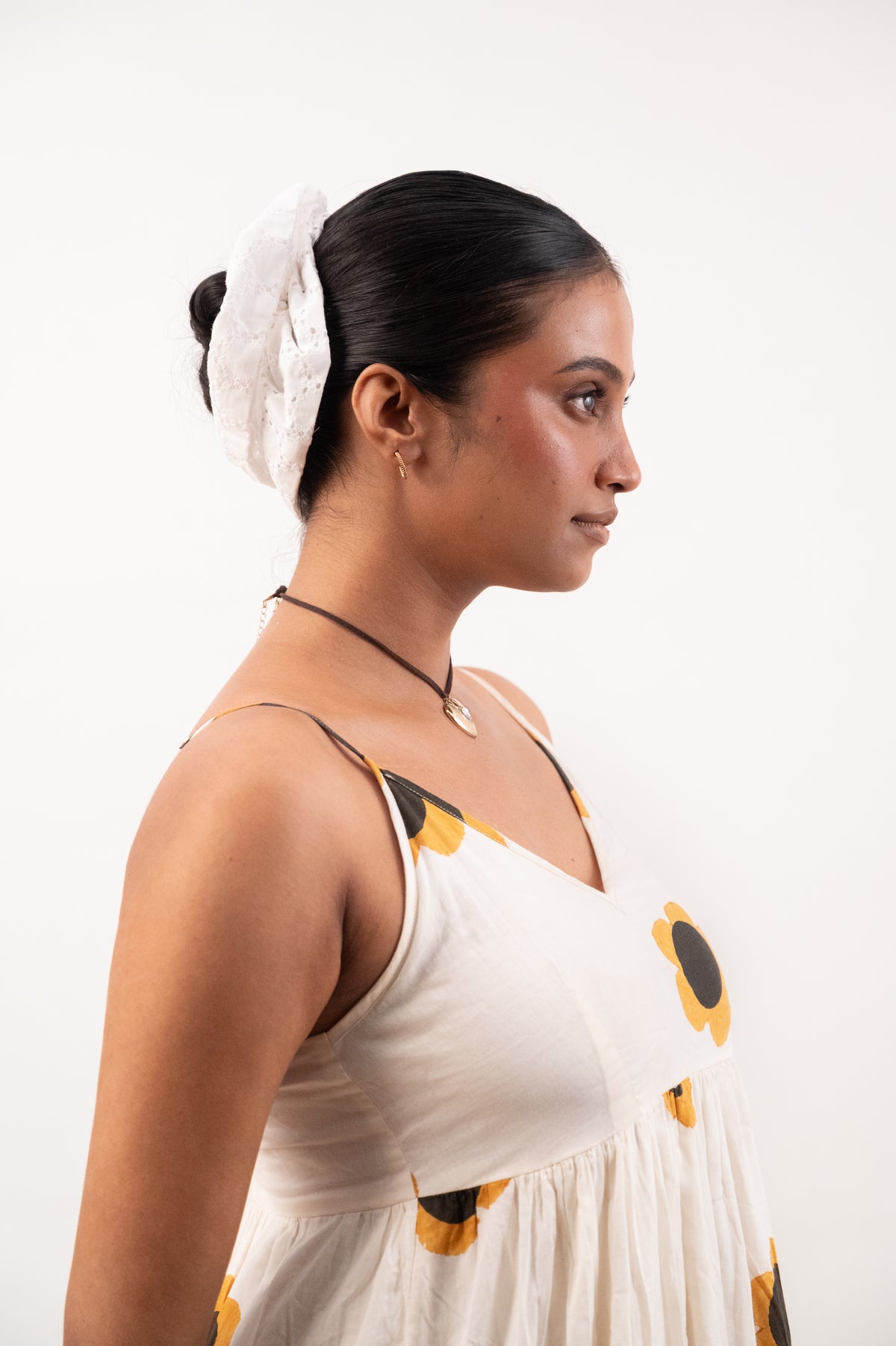 Side profile, hair gathered into a bun with Cloudy, the white chikankari scrunchie