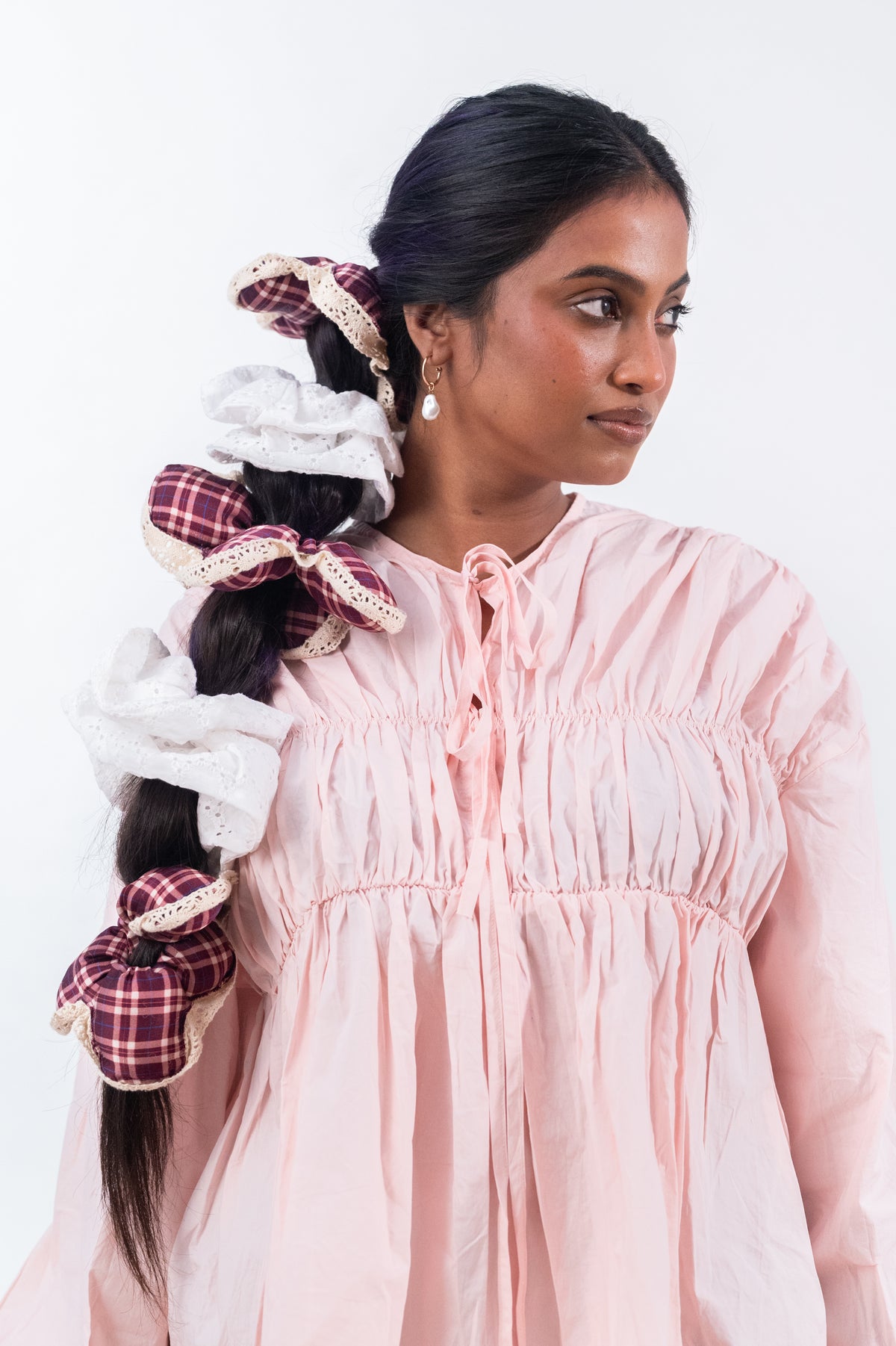A long braid finished with Cloudy and the maroon plaid Wildpetal, worn with a pink dress