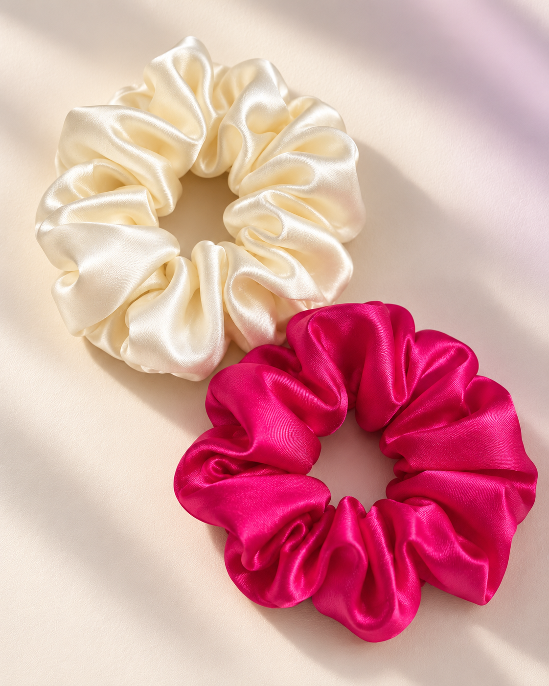 Candy Pop mulberry silk charmeuse scrunchies in Antique White and Hot Pink, laid flat in soft light