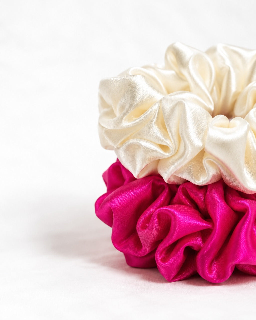 Close-up of the hand-gathered folds and sheen of a Candy Pop mulberry silk scrunchie