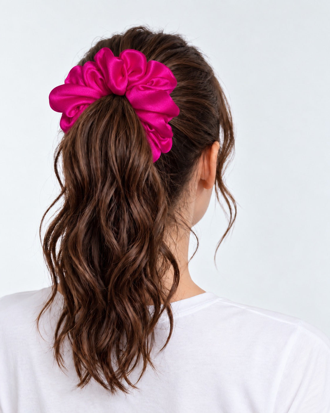 Candy Pop mulberry silk scrunchie in Hot Pink, holding a high ponytail