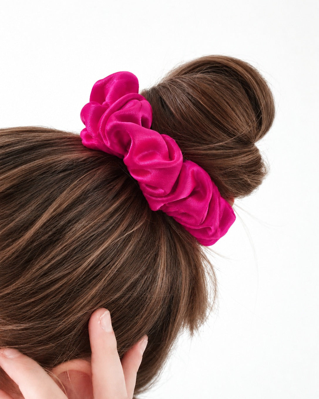 Candy Pop mulberry silk scrunchie in Hot Pink, wrapped around a top bun