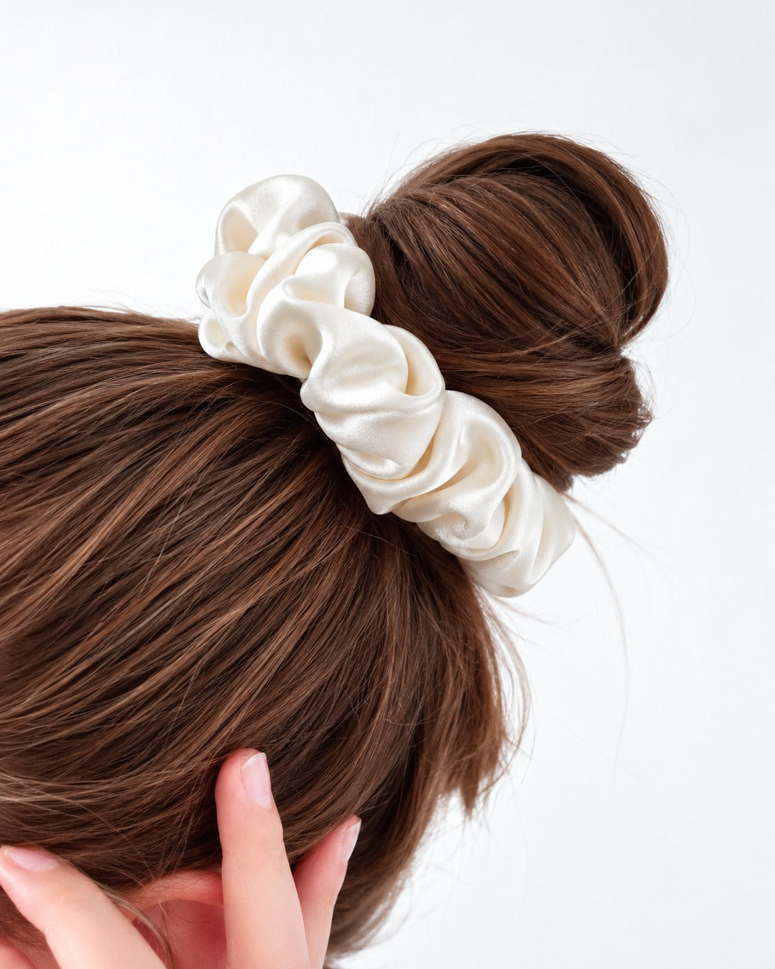 Candy Pop mulberry silk scrunchie in Antique White, wrapped around a top bun