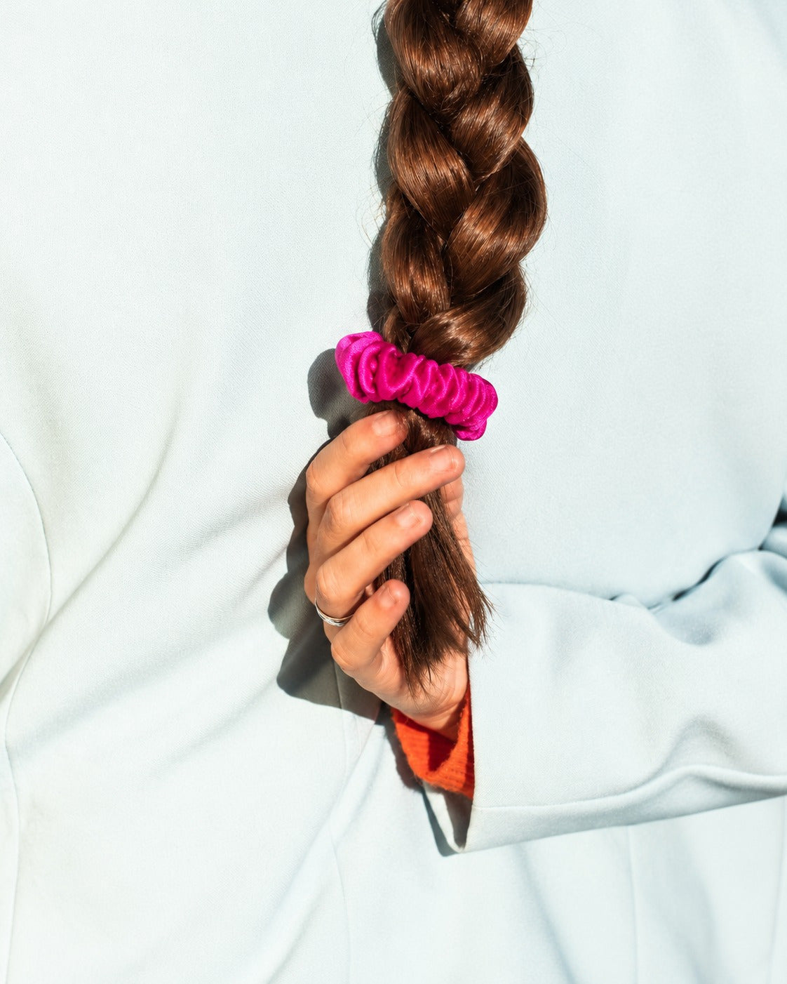 Candy Dot skinny mulberry silk scrunchie in Hot Pink at the end of a long braid